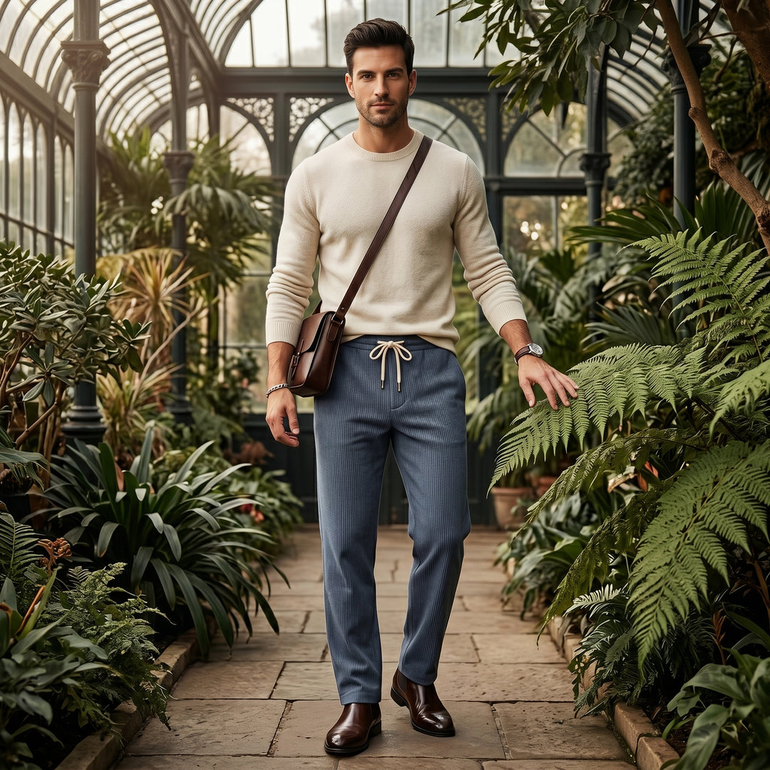 Herren Cordhose in Blau mit hellem Pullover und Umhängetasche kombiniert, Styling im Wintergarten