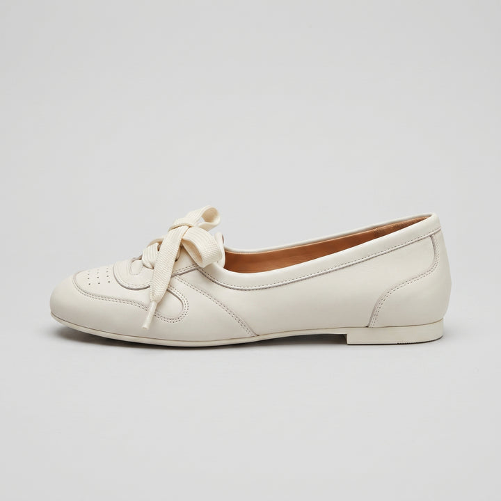 Cremeweiße Damen-Ballerina Seitenansicht mit Schnürschleife und Brogue-Perforierung