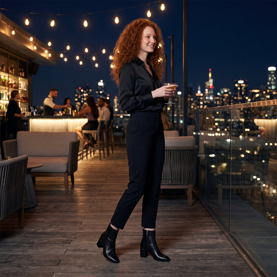 Damen-Model trägt schwarze Stiefeletten auf Rooftop-Terrasse – Ganzansicht