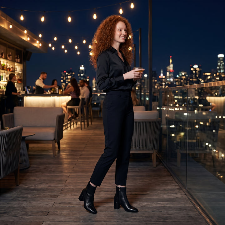 Damen-Model trägt schwarze Stiefeletten auf Rooftop-Terrasse – Ganzansicht