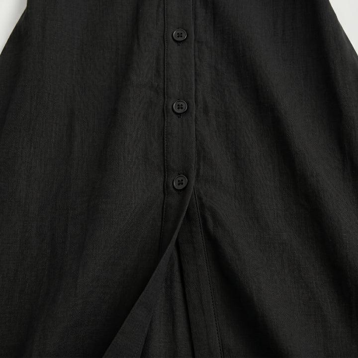 Detailansicht Knopfleiste und Beinschlitz am Plissee Maxikleid in Schwarz