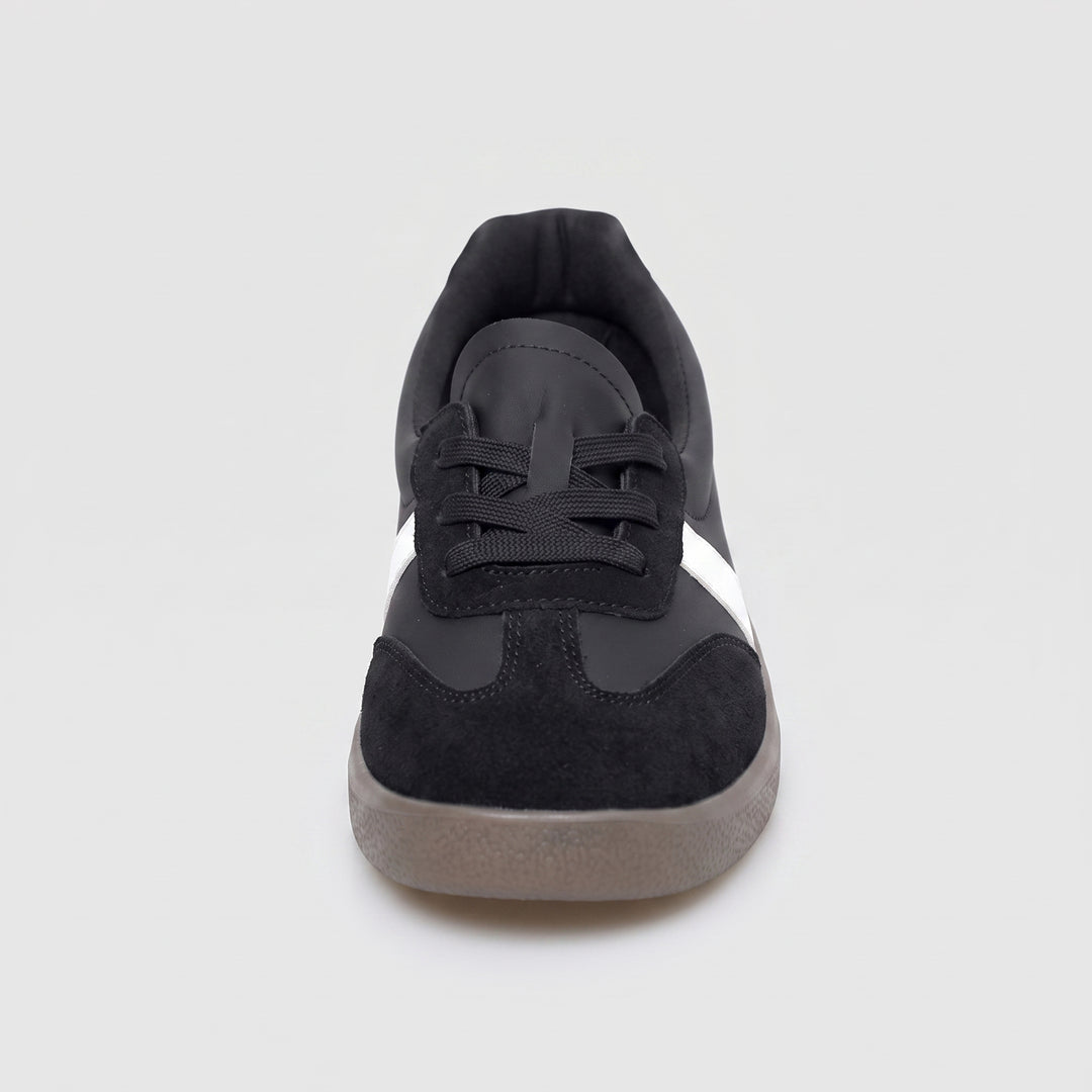 Schwarzer Damen-Sneaker Frontansicht, runde Wildleder-Zehenkappe, weißer Streifen sichtbar