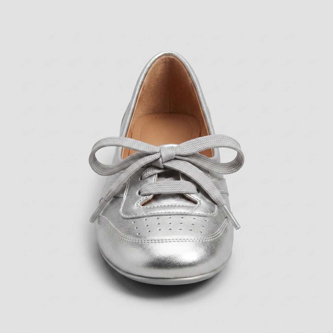 Silberne Damen-Ballerina von vorne, breite Schnürschleife und Brogue-Perforierung
