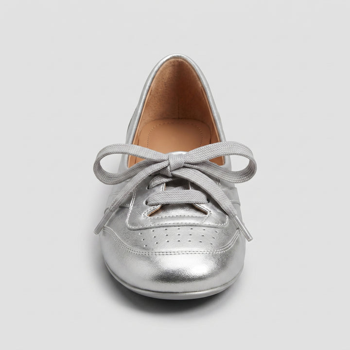 Silberne Damen-Ballerina von vorne, breite Schnürschleife und Brogue-Perforierung
