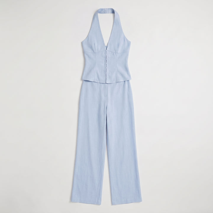 Hellblaues Weste-Hose-Set flach liegend, Neckholder-Weste mit Knöpfen und weite Hose