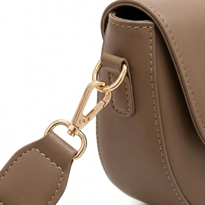 Nahaufnahme goldener Karabiner an Satteltasche Hellbraun