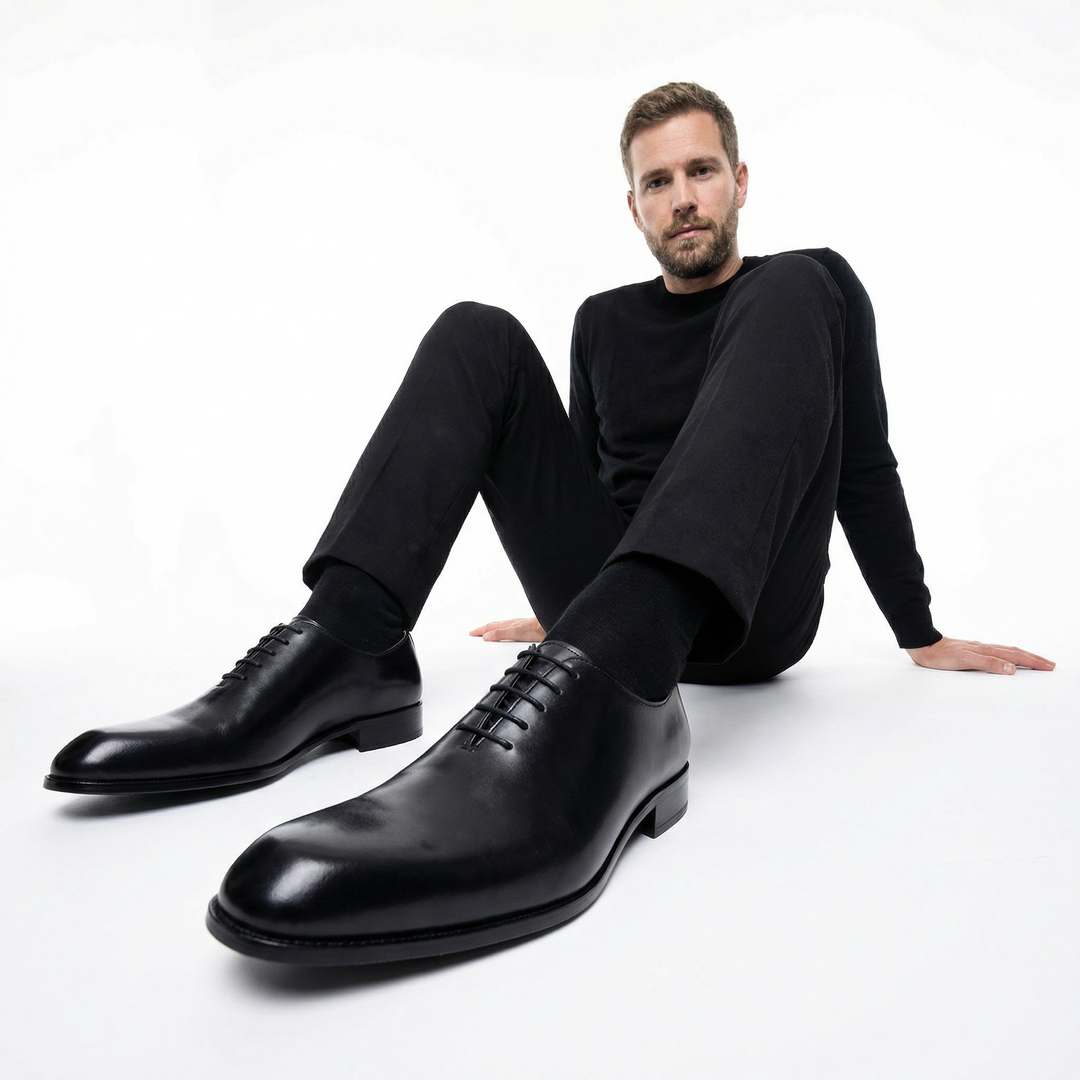Herren Oxford-Schnürschuh Schwarz am Fuß eines Models, klassisch-eleganter Look