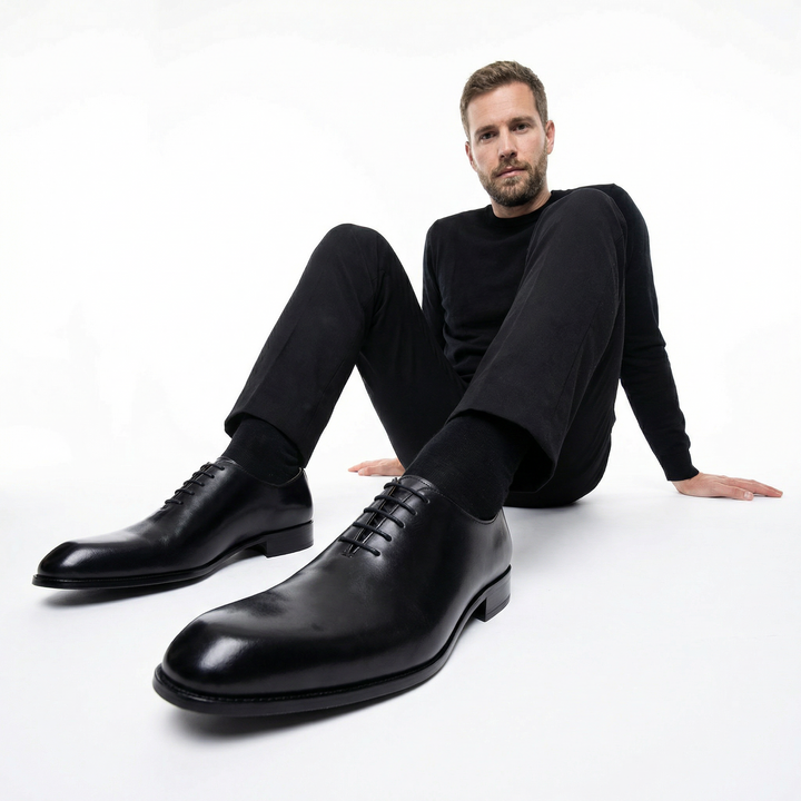 Herren Oxford-Schnürschuh Schwarz am Fuß eines Models, klassisch-eleganter Look