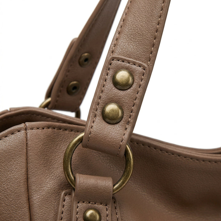 Detailaufnahme Henkelansatz taupefarbene Tasche mit goldenen Nieten und D-Ring