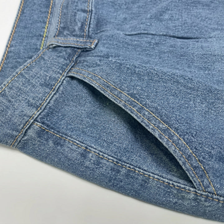 Wide-Leg Jeans Nahaufnahme Fronttasche mit goldenen Ziernähten, Denim-Textur