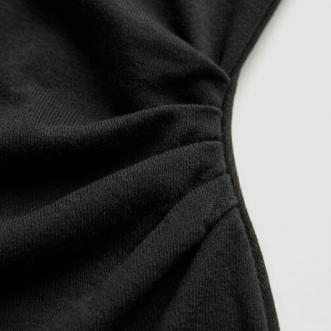 Detailaufnahme der seitlichen Raffung, Jersey-Strickoptik des schwarzen Midikleids
