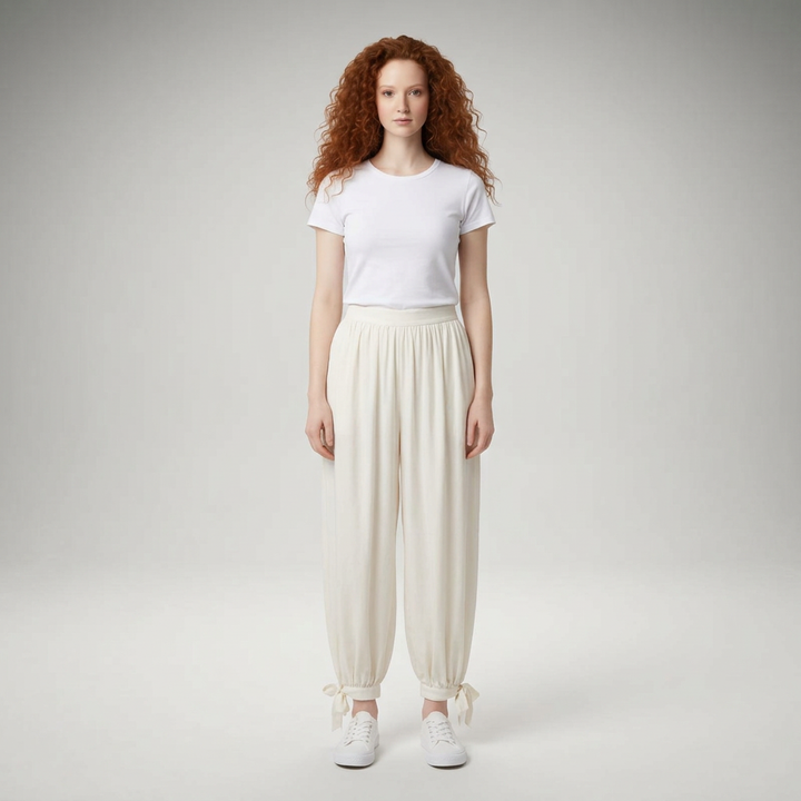 Weite Ballonhose in Creme mit Schleifenbändern am Saum, Vorderansicht am Model