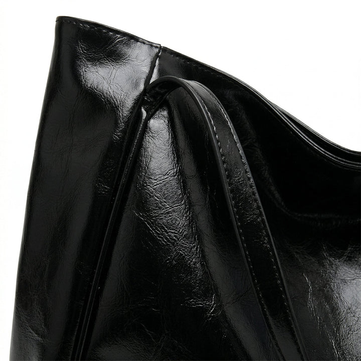Nahaufnahme schwarze Shopper-Tasche mit Glanzeffekt, Henkelansatz