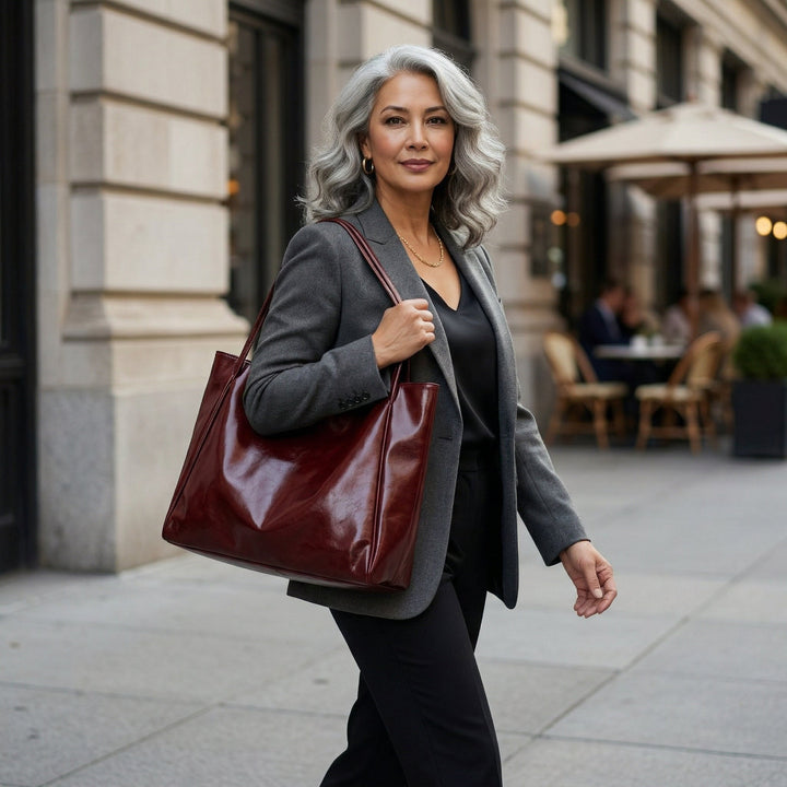 Model trägt bordeauxrote Shopper-Tasche zum grauen Blazer, eleganter Stadtstyle