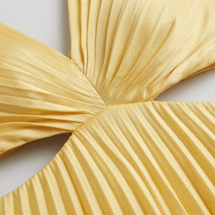 Nahaufnahme des Knoten-Details und Plisseestoffes am Midikleid in Gelb